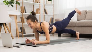 Fit,Woman,Doing,Yoga,Plank,And,Watching,Online,Tutorials,On