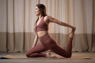 Frau macht in nachhaltiger Sportmode Yoga