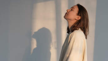 Frau steht in Sonne