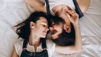 Mann und Frau kuscheln im Bett