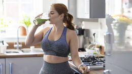 Redhead woman drinking healthy milkshake after working out at home