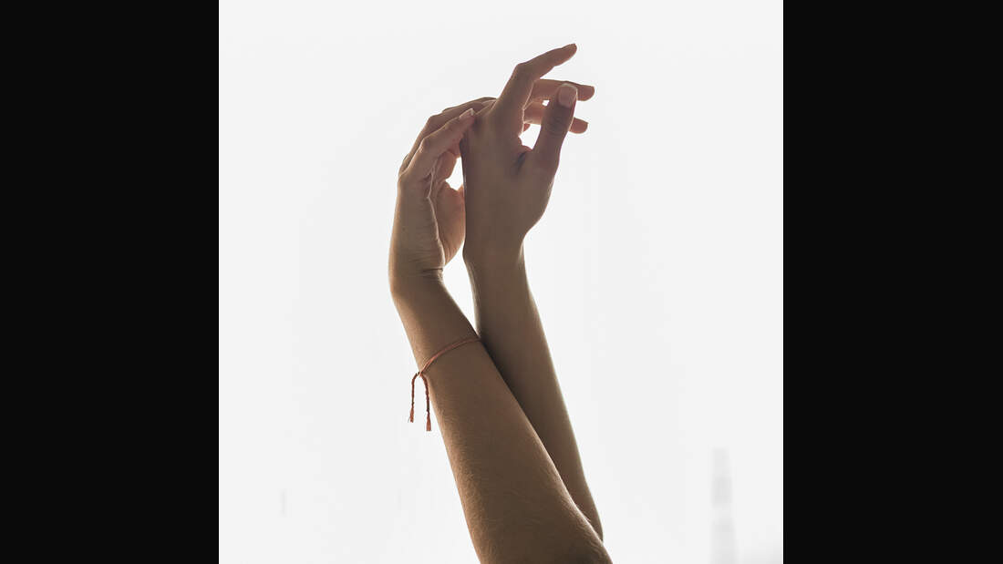Woman Raising Hands Against A Window