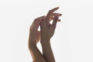 Woman Raising Hands Against A Window