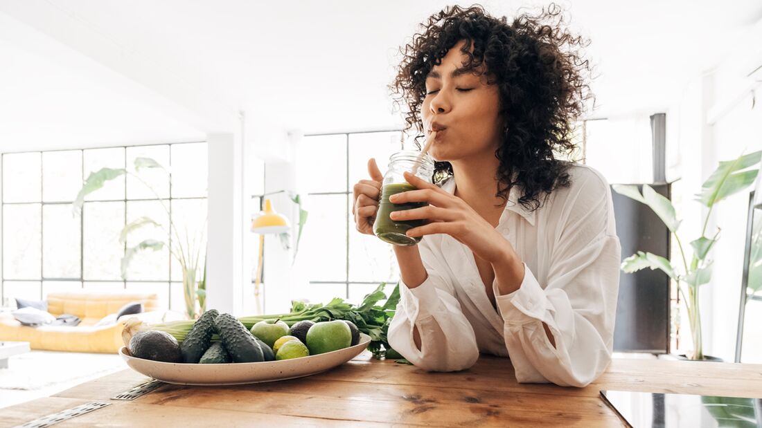 Young,African,American,Woman,Drinking,Green,Juice,With,Reusable,Bamboo