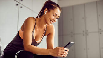 Young,Athletic,Woman,Using,Smart,Phone,And,Text,Messaging,In