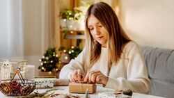 junge Frau packt Weihnachtsgeschenke ein